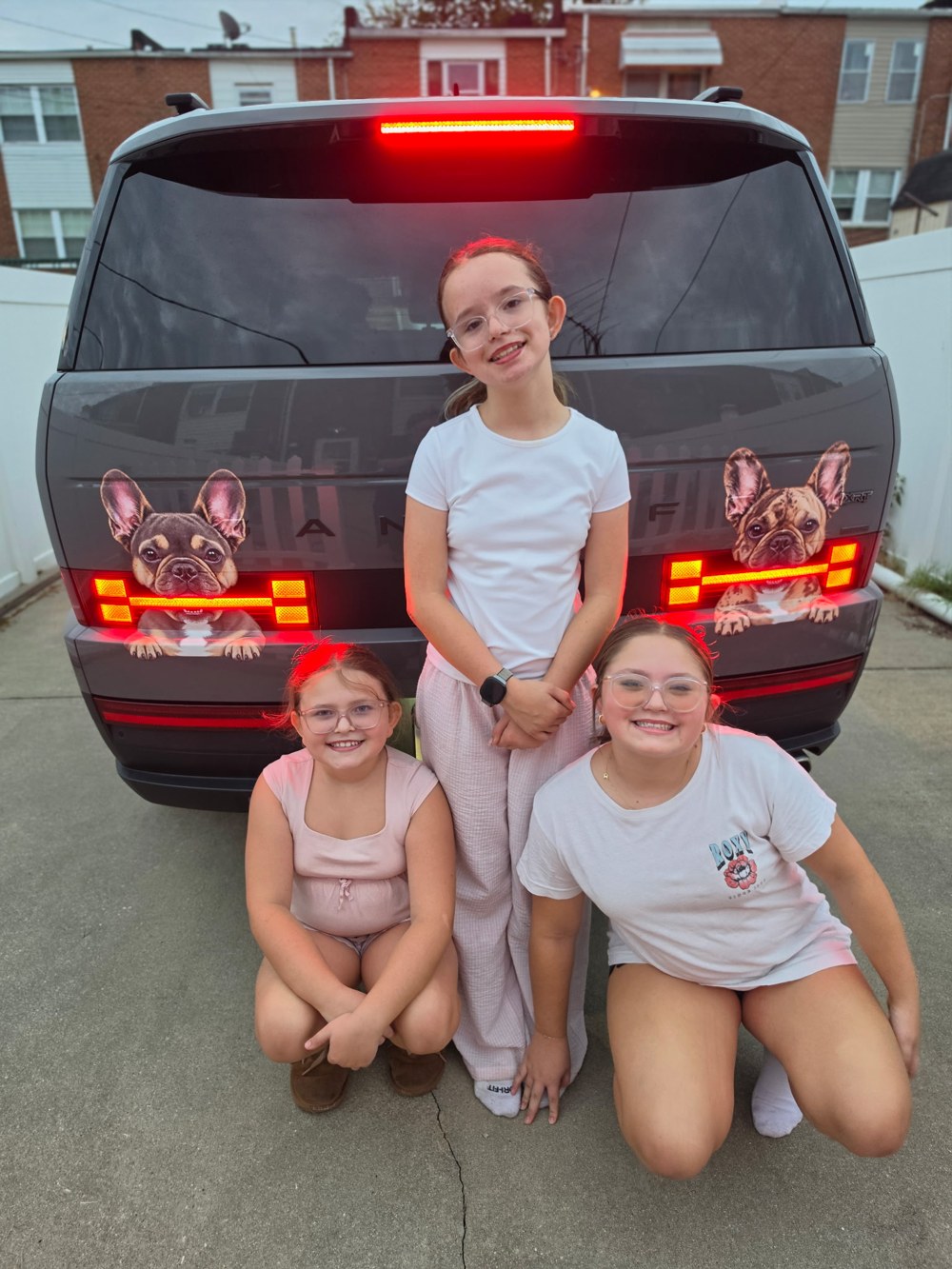 Our first Garebone customer’s family smiling beside their Santa Fe with two illuminated Frenchie decals